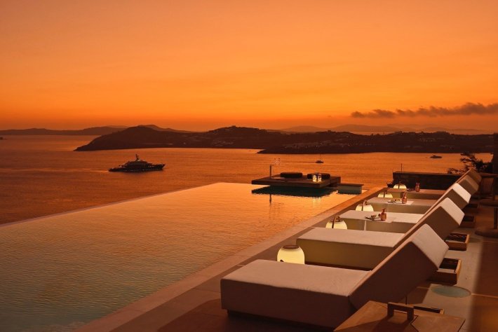 Best infinity pools in the world: one of the best infinity edge plunge pools located in a villa with a sloped yard in Greece, the concentration of the best infinity pools with a view. The villa boasts contemporary stone and concrete interiors.